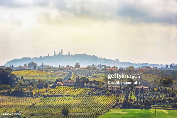 landschaft in der toskana, mit san gimignano in der ferne - san gimignano stock-fotos und bilder