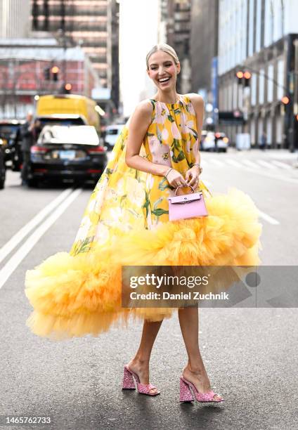 Leonie Hanne is seen wearing a yellow floral Carolina Herrera dress, pink bag and pink shoes outside the Carolina Herrera show during New York...