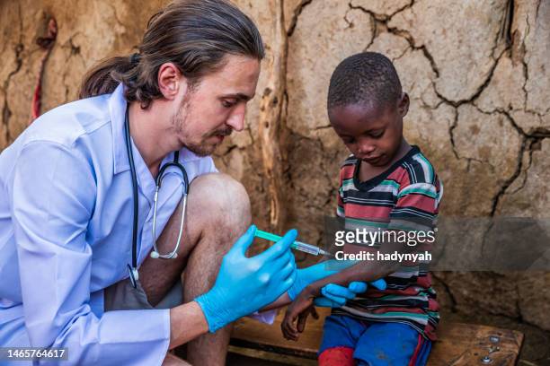 doctor is doing an injection to little african boy in small village, kenya - doctors without borders 個照片及圖片檔
