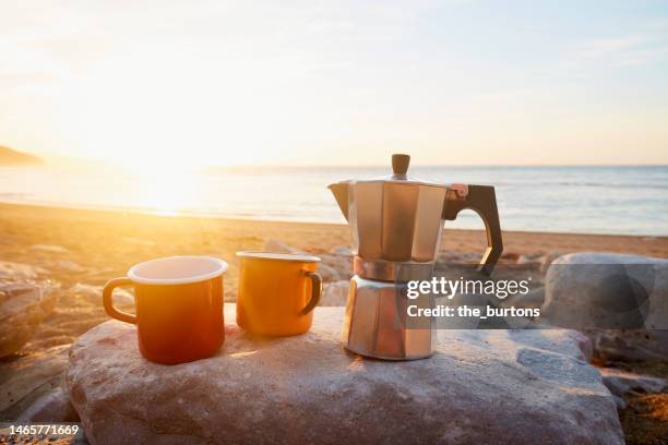 two enamel coffee cups and a  by the sea during sunset - sea cup stock pictures, royalty-free photos & images