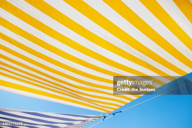 striped awning on the beach against blue sky - striped awning stock pictures, royalty-free photos & images