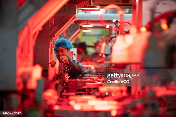 An employee works on the production line of solar panels at a factory on February 14, 2023 in Jinhua, Zhejiang Province of China.