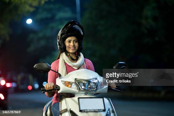 happy woman riding motorcycle with helmet at night - sports helmet stock pictures, royalty-free photos & images