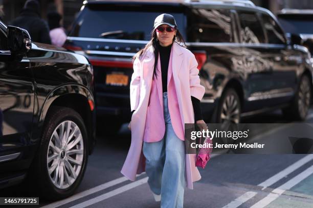 Miki Cheung wears a pale pink oversized long coat, a pale pink denim blazer jacket, a Valentino neon pink leather with flower pattern handbag, black...