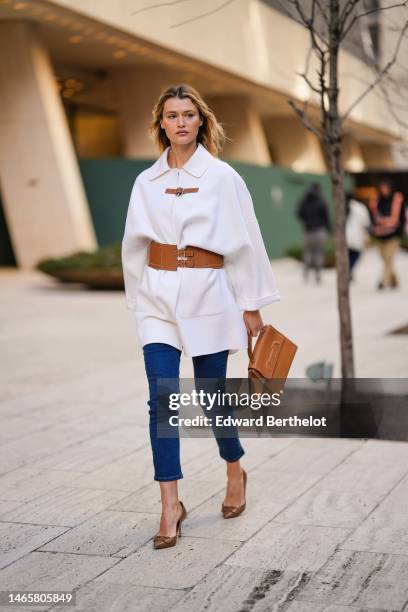 Guest wears a white shirt neck / wool coat with a camel shiny leather large belt, a camel shiny leather handbag from Carolina Herrera, navy blue...