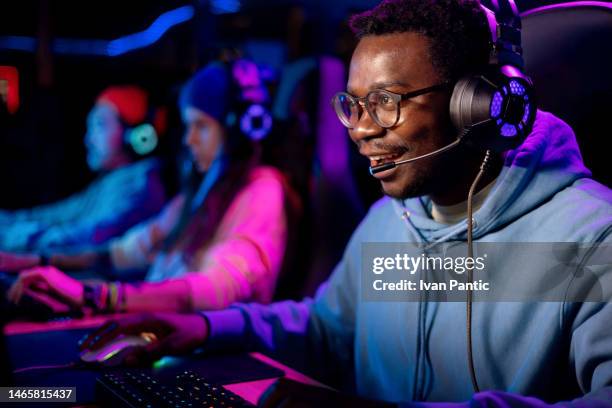 black male gamer enjoying in video game at entertainment club. - microsoft media & entertainment group stock pictures, royalty-free photos & images