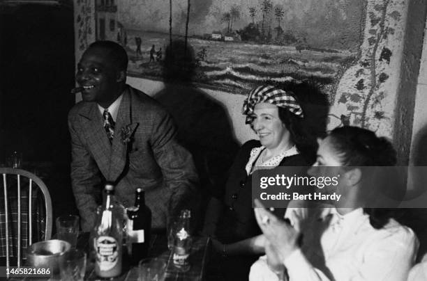 Group of friends enjoy a drink in a bar, 1949. Original Publication: Picture Post - 4825 - Is There A British Colour Bar? - pub. 2nd July 1949