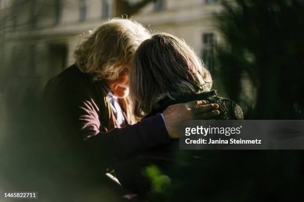 rear view of senior couple with arm around each other - love emotion stock-fotos und bilder