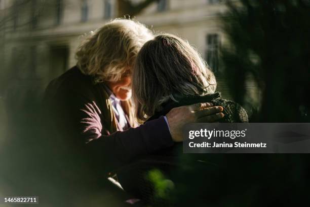 rear view of senior couple with arm around each other - emociones fotografías e imágenes de stock
