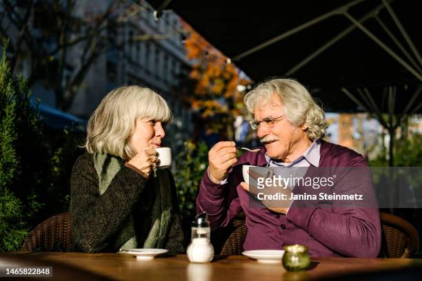 loving senior couple taking a coffee break at cafe - senior men cafe stock pictures, royalty-free photos & images