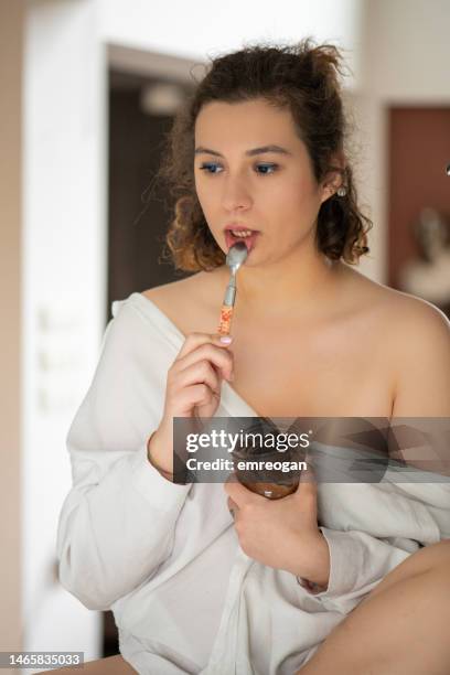 young woman spooning chocolate in the kitchen - forma de queque imagens e fotografias de stock