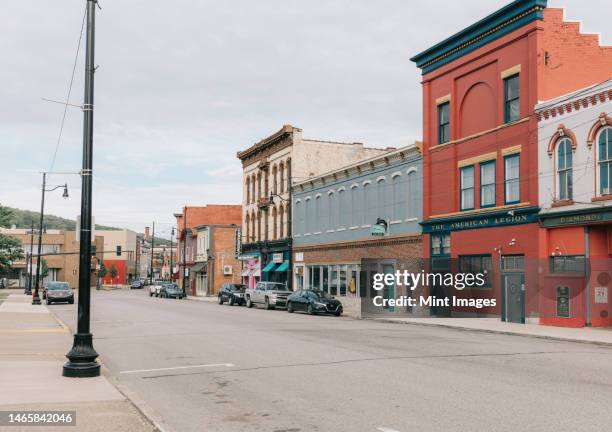 empty storefronts and buildings along a quiet main street - high street stock-fotos und bilder