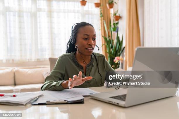 schwarze geschäftsfrau mit kopfhörern und laptop, - grünes hemd stock-fotos und bilder