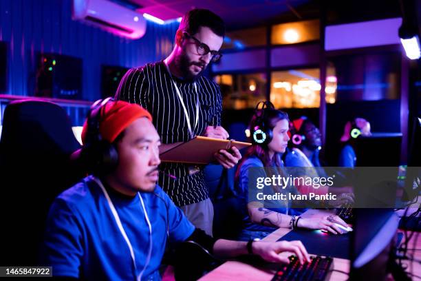 male judge supervising gamers during an esports competition in entertainment club. - microsoft media & entertainment group stock pictures, royalty-free photos & images