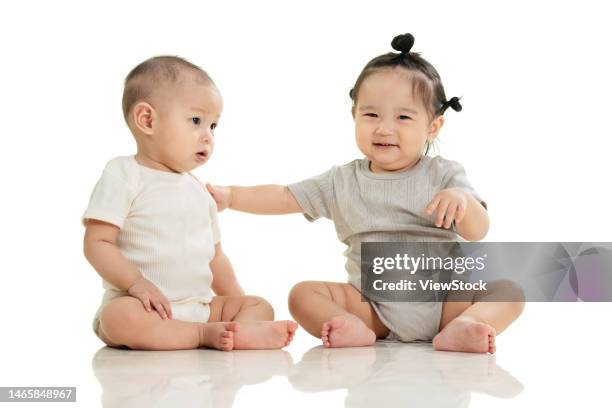 playing two cute baby sitting on the ground - baby boy and girl stockfoto's en -beelden