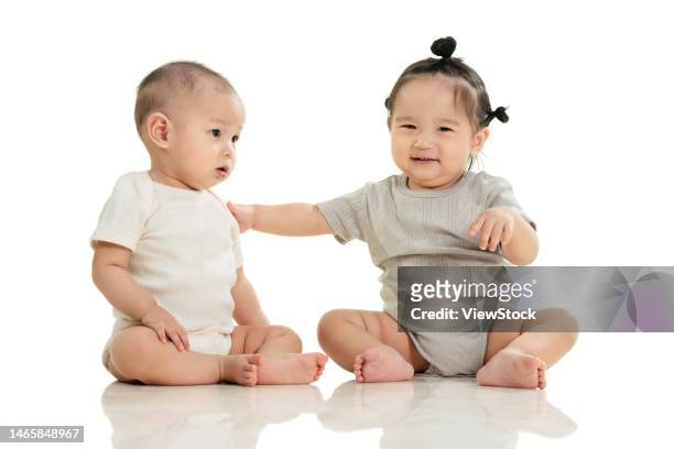 playing two cute baby sitting on the ground - baby boy and girl stock pictures, royalty-free photos & images