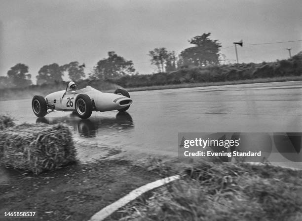 British racing driver Stirling Moss in his UDT-Laystall Racing Team Lotus 18/21 car , driving in the rain, during the 6th Silver City Trophy race,...