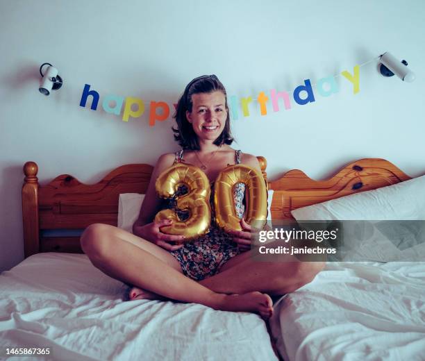 festa di compleanno per i 30 anni. sedersi sul letto e tenere in mano il cartello gonfiabile 30 - 30 34 years foto e immagini stock