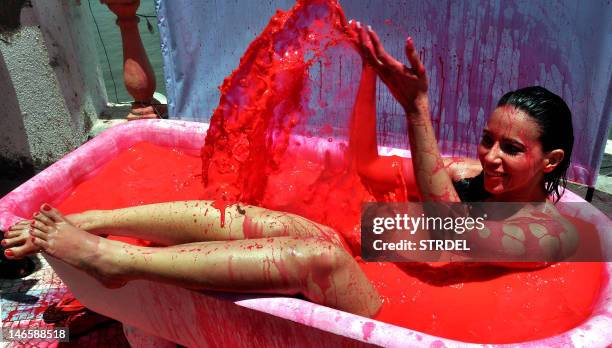 Indian Bollywood actress and model Rozlyn Khan bathes in a bath tub filled with red coloured water, as part of a protest against the use of animal...