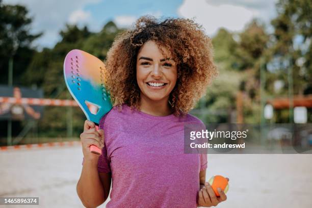 portrait of woman playing beach tennis looking at camera - sportsperson stock pictures, royalty-free photos & images