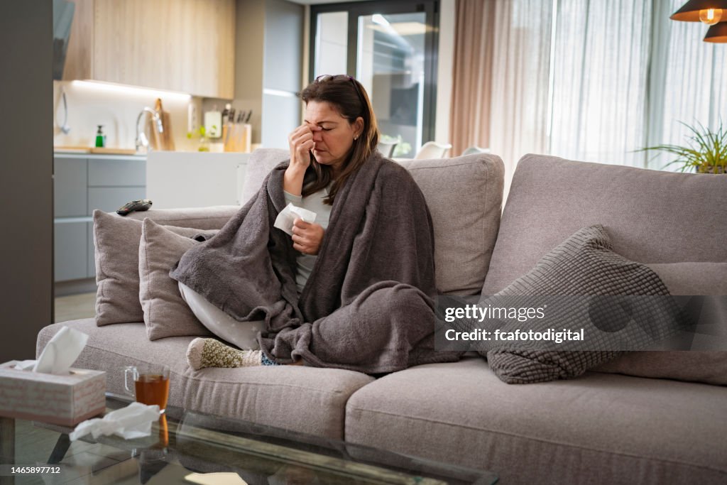 Sick woman with flu sitting on sofa