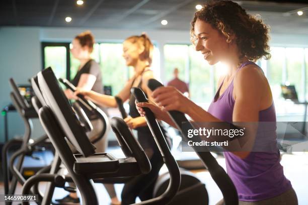 cross trainer women at the gym - stair climbing machine stock pictures, royalty-free photos & images