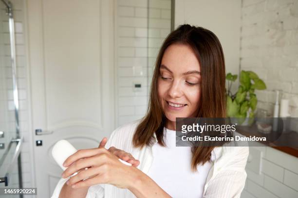 woman testing cream on her hand in the bathroom - cosmetic testing store stock pictures, royalty-free photos & images