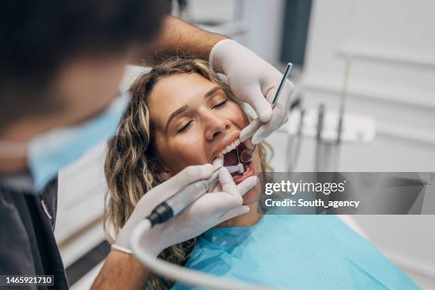 woman having teeth repaired - tandartsboor stockfoto's en -beelden