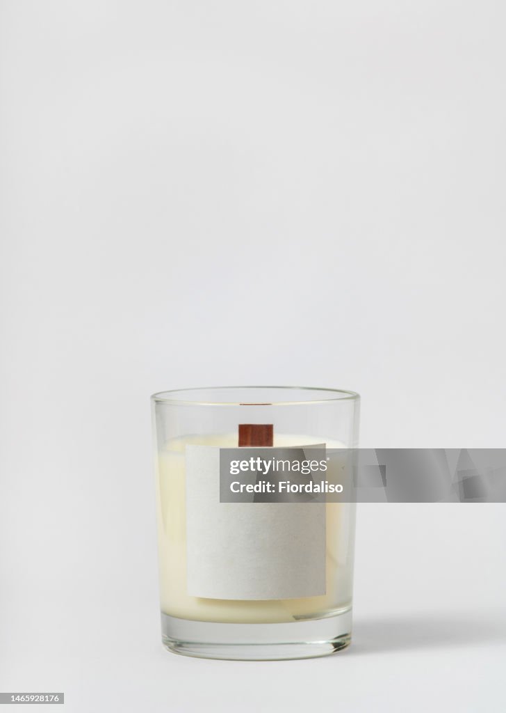 White candle bottle on a light gray background