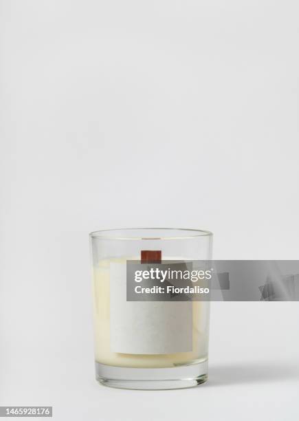 white candle bottle on a light gray background - kaarsen stockfoto's en -beelden