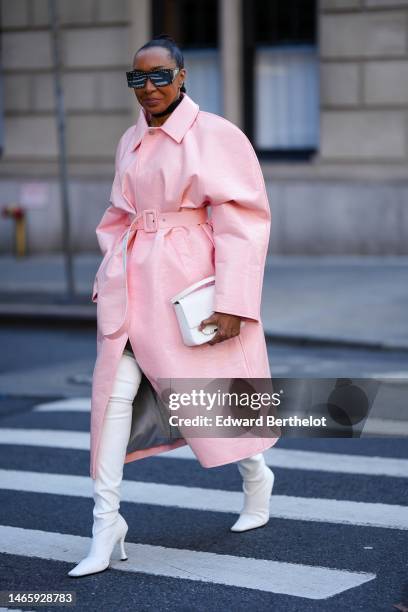 Guest wears black nailed / studded futurist sunglasses, gold earrings, a black necklace, a pale pink shiny leather crocodile print pattern belted...