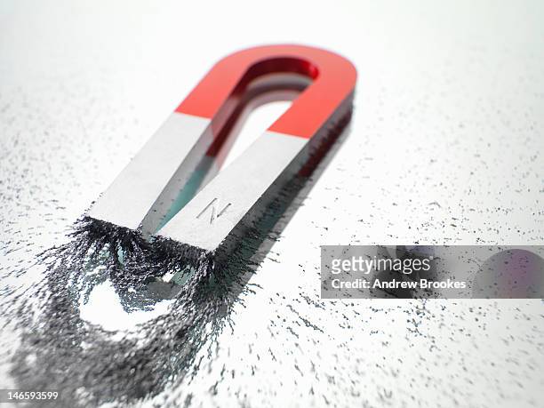 close up of magnet and iron filings - magnetic field stock pictures, royalty-free photos & images