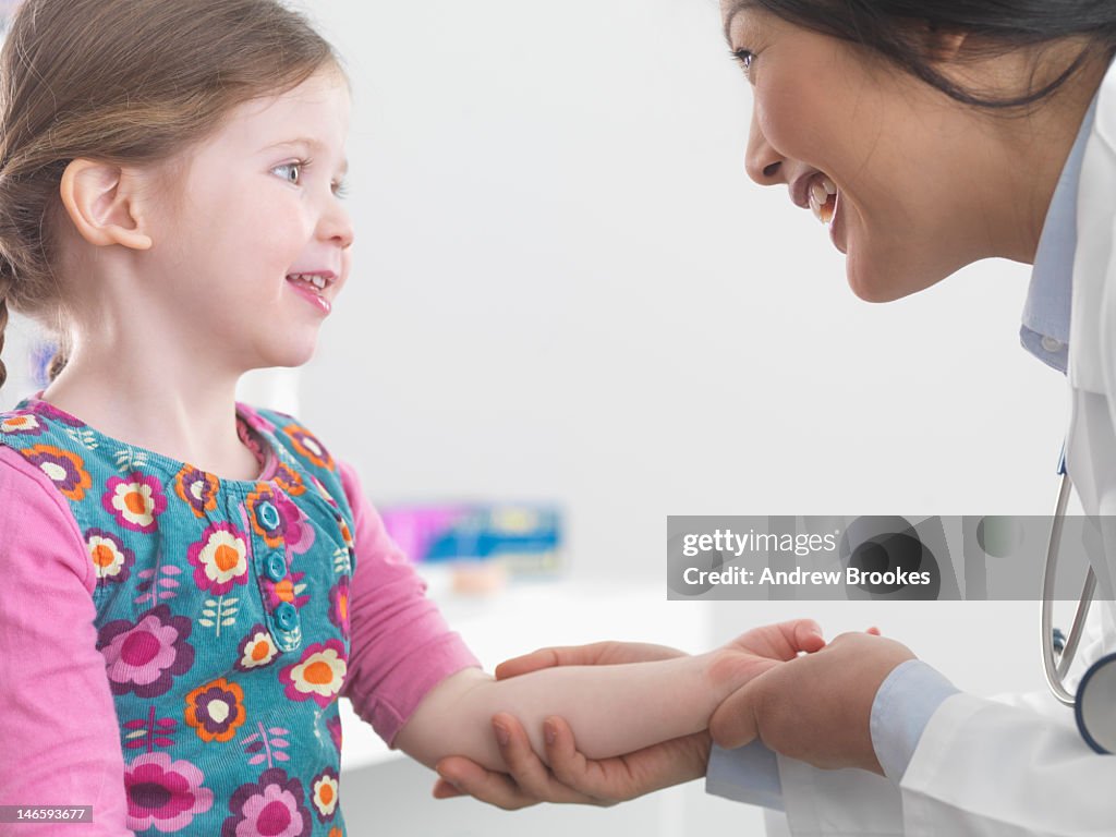 Doctor examining girl in office