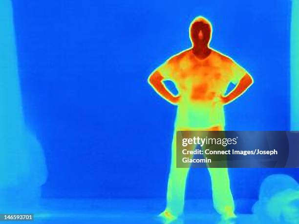 thermal image of man standing against wall - termografia imagens e fotografias de stock