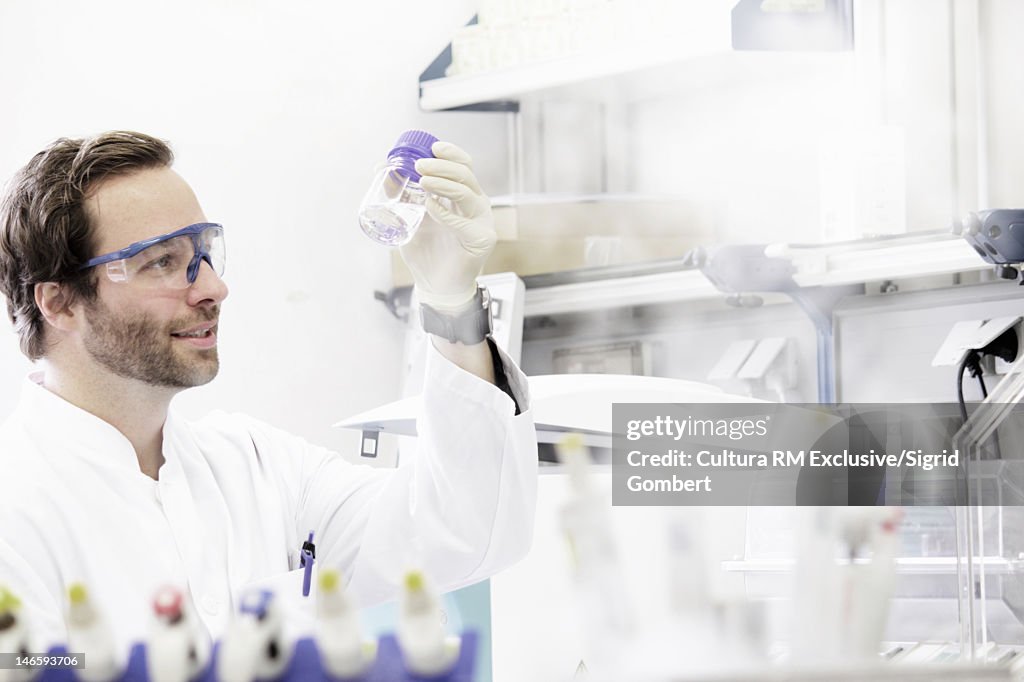 Scientist examining jar in lab