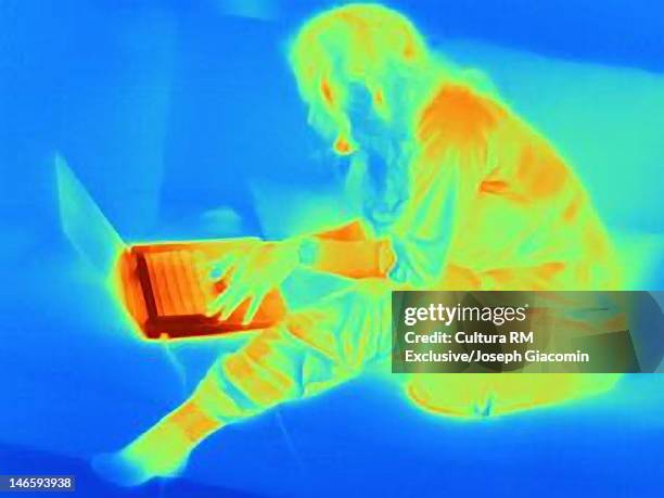 thermal image of woman using laptop on sofa - thermal imaging stock pictures, royalty-free photos & images