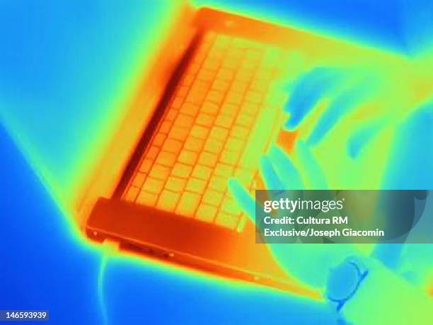 thermal image of hands using laptop - wärmebild stock-fotos und bilder