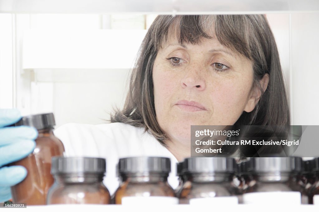 Scientist examining jars in lab