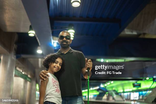 portrait of blind father and daughter at a subway station - blind girl stock pictures, royalty-free photos & images