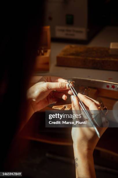 woman jeweller looking gemstone - jewelled stockfoto's en -beelden