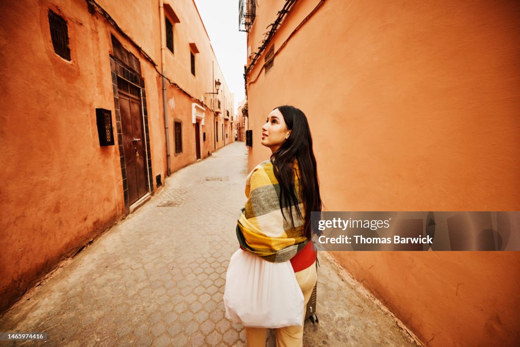 Wide shot of woman exploring the Medina of Marrakech while on vacation