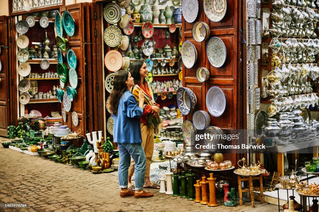 Wide shot of friends exploring and shopping in the souks of Marrakech