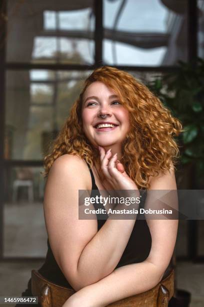 porträt einer attraktiven und üppigen jungen frau, die im hintergrund im studio posiert - beautiful chubby woman stock-fotos und bilder