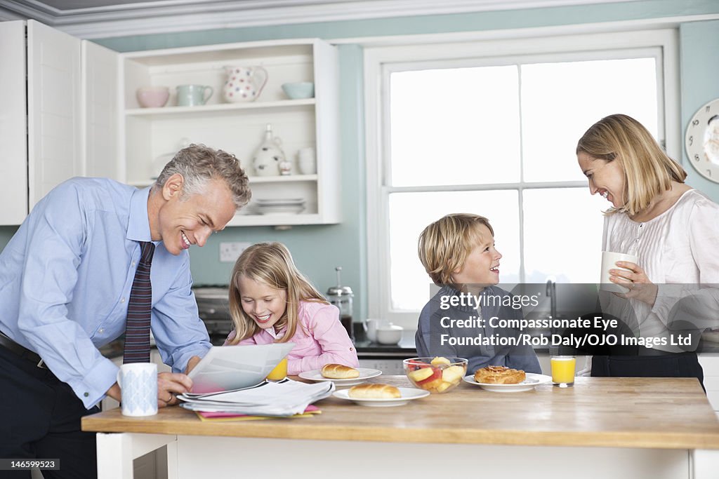 Family relaxing in kitchen with digital tablet