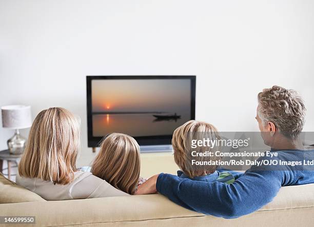 family watching television, rear view - family watching tv together stock pictures, royalty-free photos & images