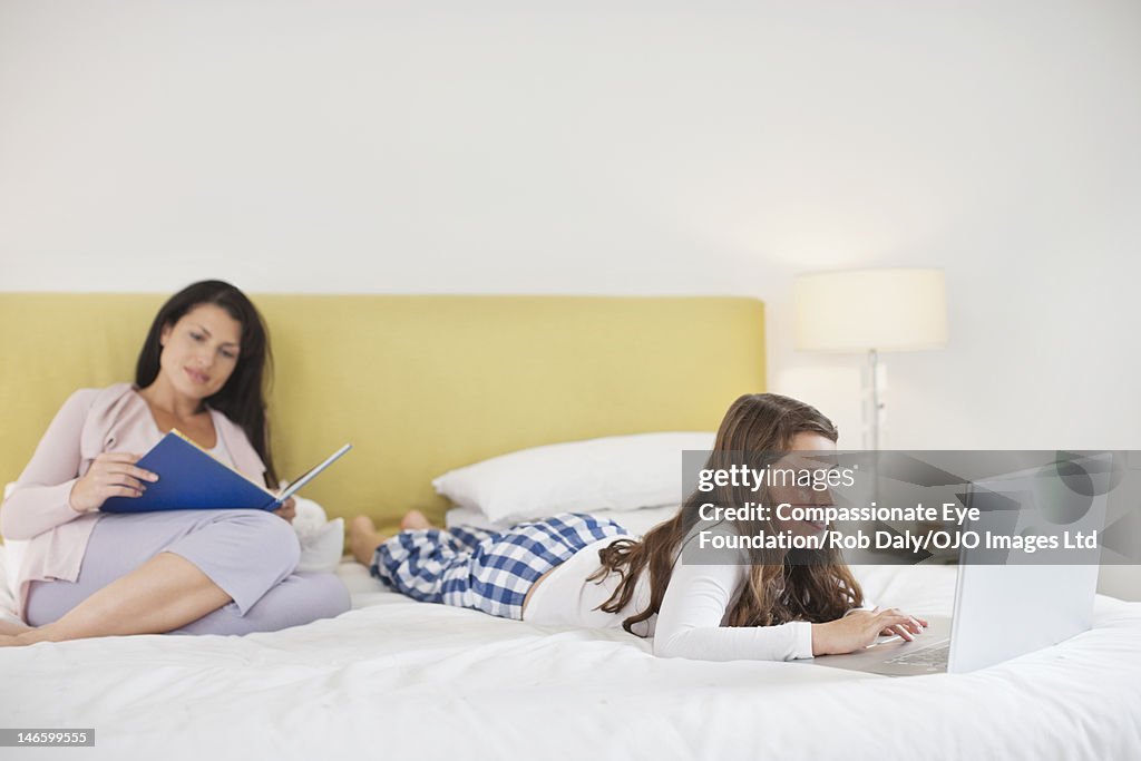 Mother and daughter relaxing in bedroom