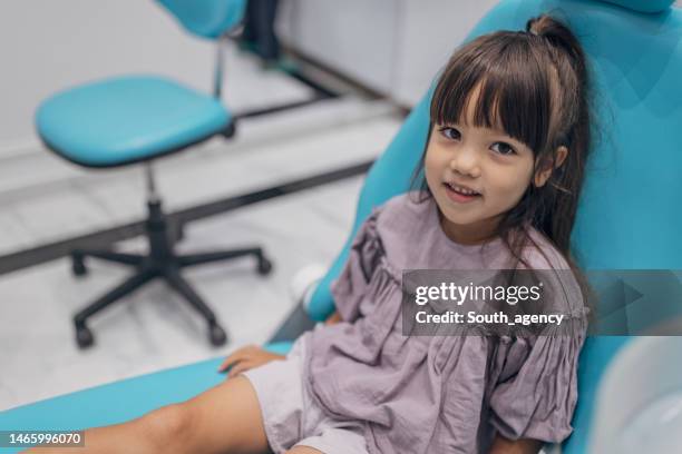 little girl at the dentist - tandartsstoel stockfoto's en -beelden