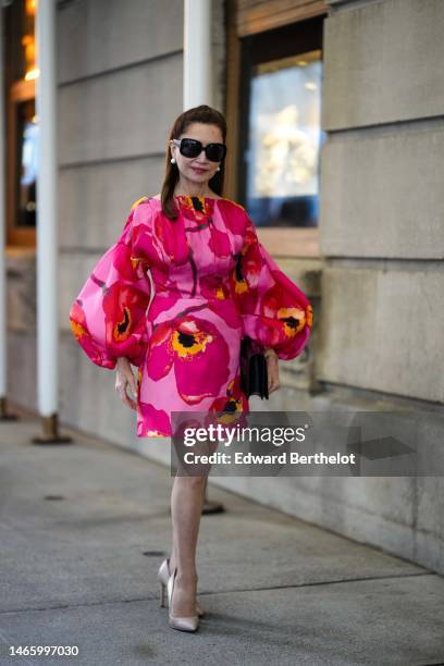 Guest wears black large sunglasses, white pearl earrings, a pale pink with pink and yellow large flower print pattern long puffy sleeves / short...