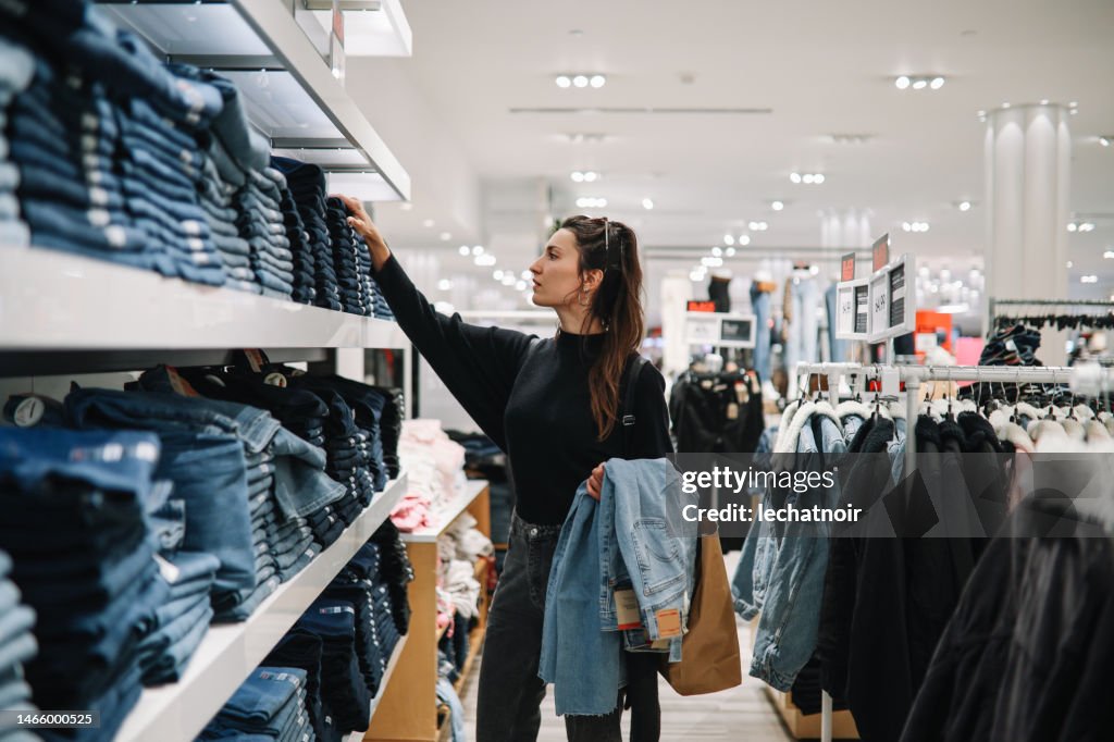 Mujer comprando jeans vaqueros en una tienda de ropa