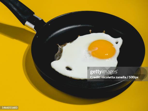 close-up of fried egg against yellow background,italy - polytetrafluoroethylene stock pictures, royalty-free photos & images